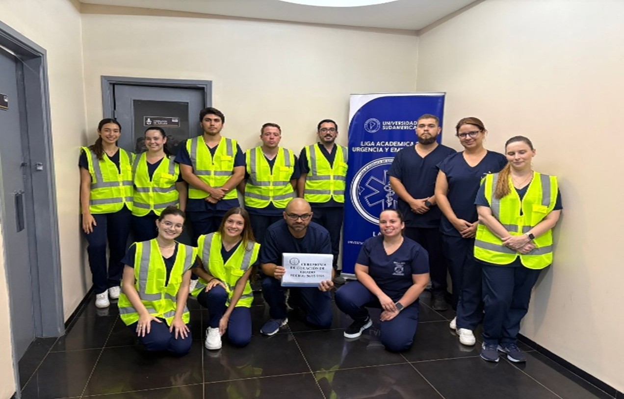Estudiantes de UNISUD con chalecos reflectantes y uniformes médicos brindando apoyo preventivo en la colación de grado.