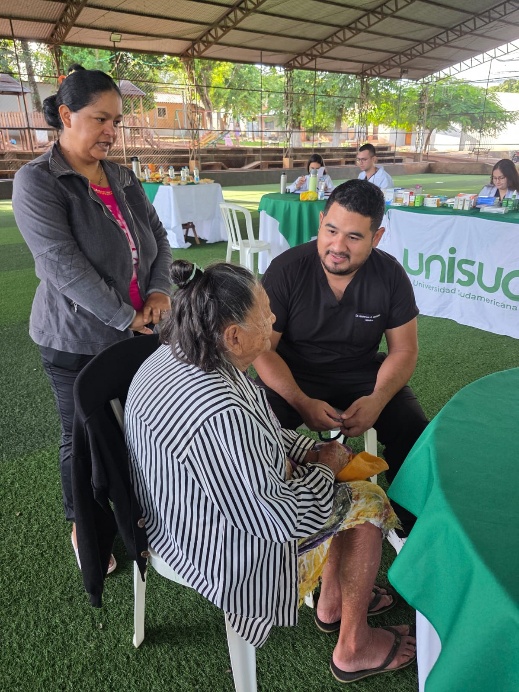 Estudiante de medicina de UNISUD brinda atención médica comunitaria a una mujer de la tercera edad en el barrio Renacer.