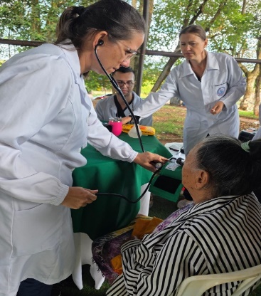 Estudiante controla la presión a una mujer mayor durante jornada de atención médica comunitaria en Saltos del Guairá.